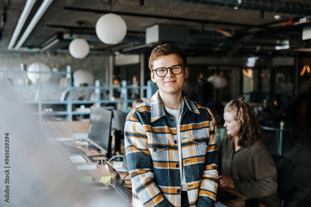 Portrait of smiling young entrepreneur in tech startup office Portrait of smiling young entrepreneur in tech startup office