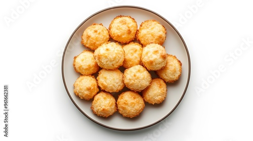 Golden coconut macaroons arranged on a plate against a white background