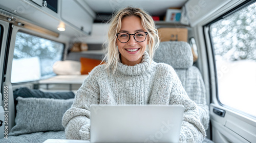 Smiling woman working remotely on laptop in camper van