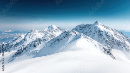 Breathtaking view of a snow-capped mountain range under a clear blue sky, capturing the pristine beauty and vastness of alpine scenery in the winter season.