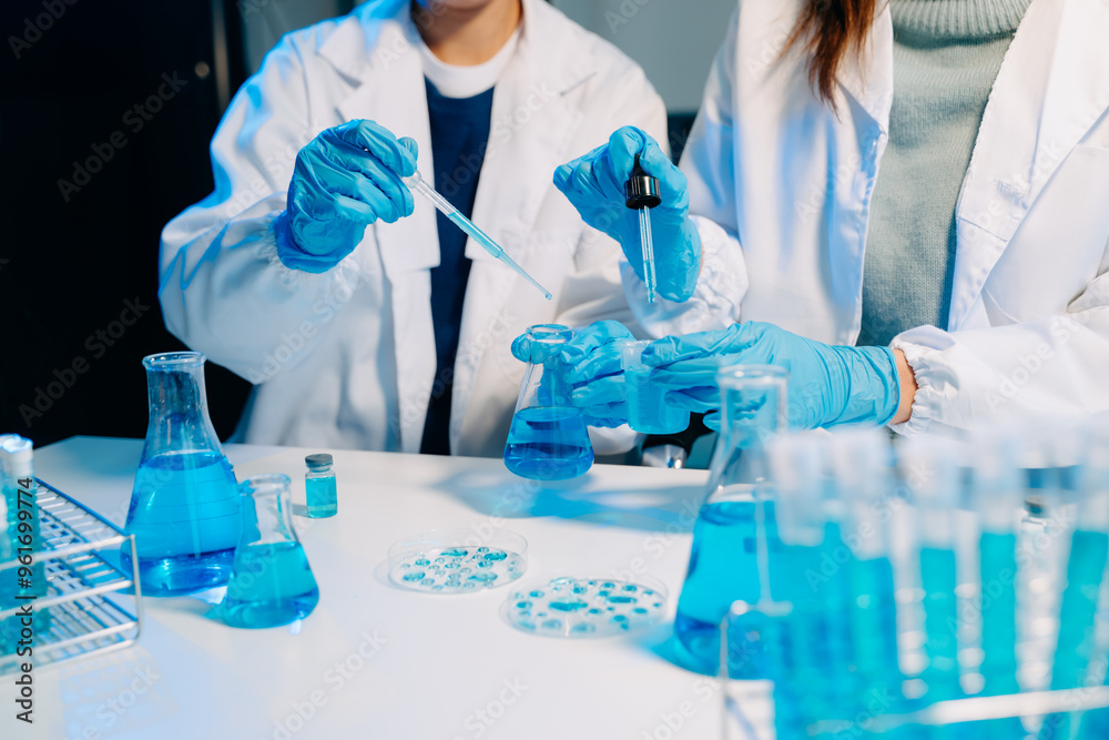 scientists in lab coats conducting research, handling glassware, and working with chemicals scientists in lab coats conducting research, handling glassware, and working with chemicals