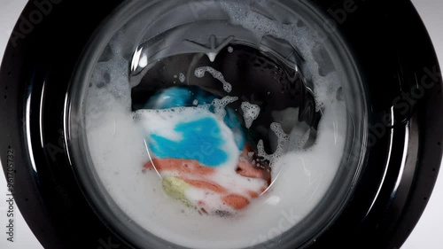 Washing Colored Laundry In A Washing Machine, Spinning Colorful Items Through A Glass Door.
