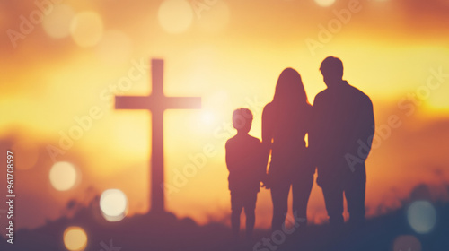 Blurry silhouette of a family standing in front of a cross 
