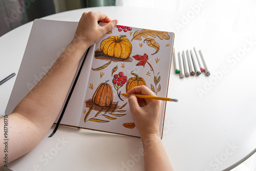 Hand drawing colorful autumn-themed illustrations in sketchbook