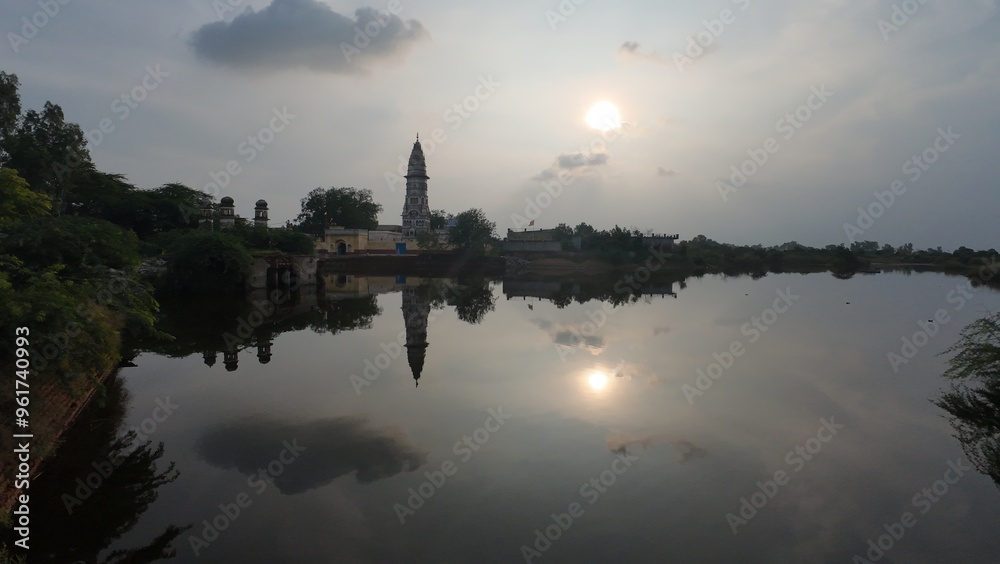 Serene sunset at the Hindu temple reflecting in the calm waters at dusk Serene sunset at the Hindu temple reflecting in the calm waters at dusk
