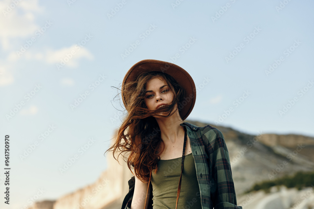 Φωτογραφία serene woman in hat and plaid shirt enjoys the scenic view of mountains on a pea