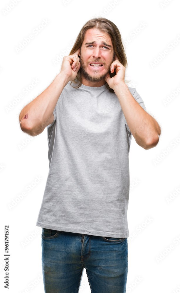 Young handsome man with long hair over isolated background covering ears with fingers with annoyed expression for the noise of loud music. Deaf concept. Young handsome man with long hair over isolated background covering ears with fingers with annoyed expression for the noise of loud music. Deaf concept.