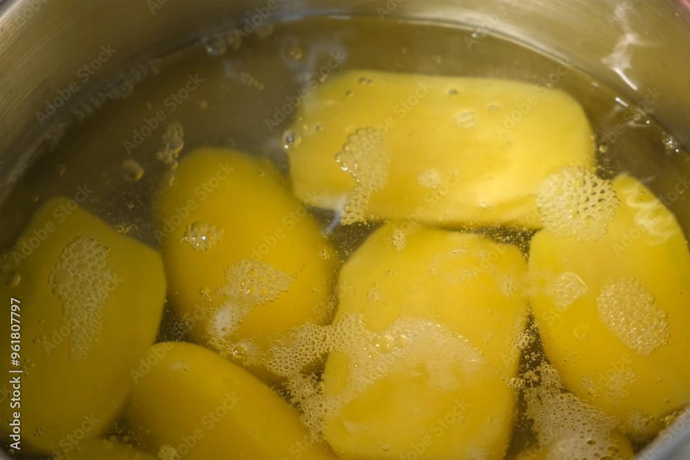 Potatoes in boiled water in saucepan, cooking dish at home on kitchen, close-up view. Cuisine, culinary, prepare cook domestic food, recipe, raw organic vegetables ingredients, products concept. Potatoes in boiled water in saucepan, cooking dish at home on kitchen, close-up view. Cuisine, culinary, prepare cook domestic food, recipe, raw organic vegetables ingredients, products concept.