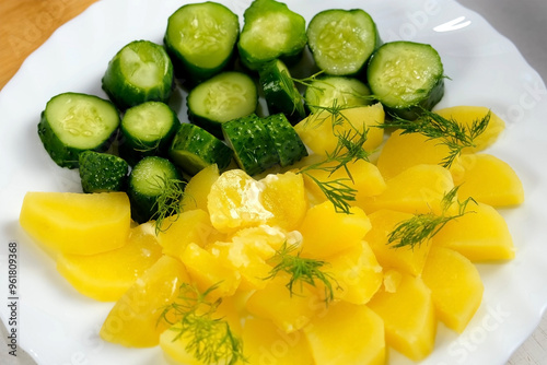 Prepared served dish with boiled potatoes, butter, pickles decorated fresh dill in white plate, close-up view. Cuisine, culinary, prepare cook, domestic food, recipe, fresh ingredients, products.