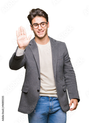 Young business man wearing glasses over isolated background Waiving saying hello happy and smiling, friendly welcome gesture photo