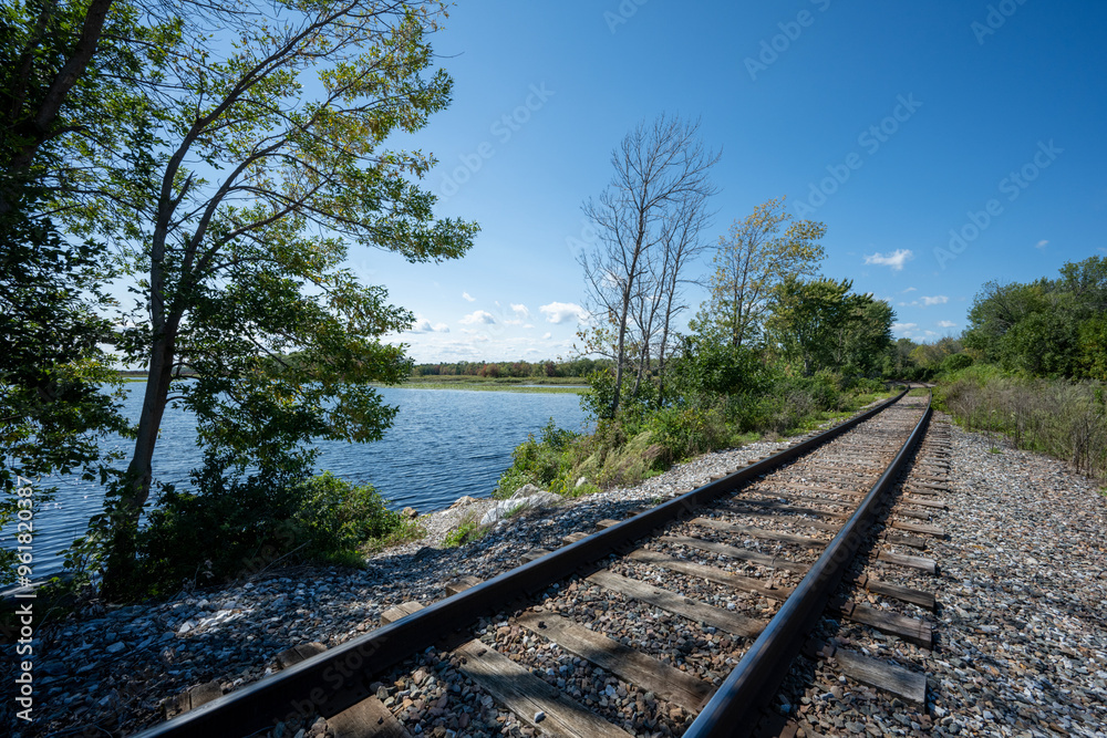 Obraz premium Railroad track in perspective at the water's edge in Vermont
