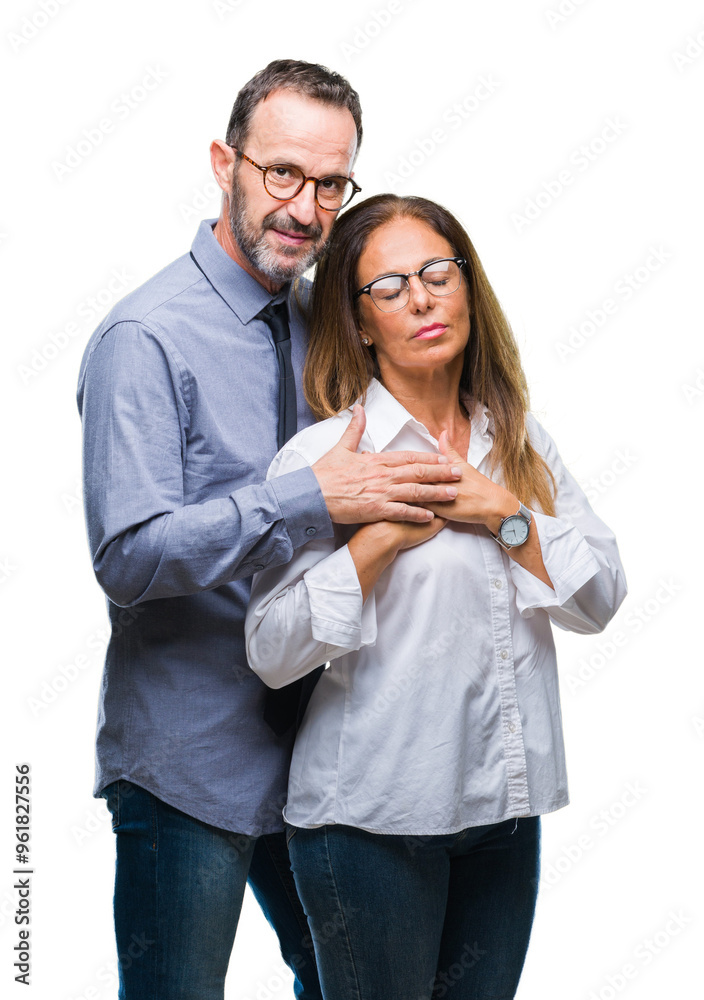 Middle age hispanic couple in love wearing glasses over isolated background smiling with hands on chest with closed eyes and grateful gesture on face. Health concept. Middle age hispanic couple in love wearing glasses over isolated background smiling with hands on chest with closed eyes and grateful gesture on face. Health concept.