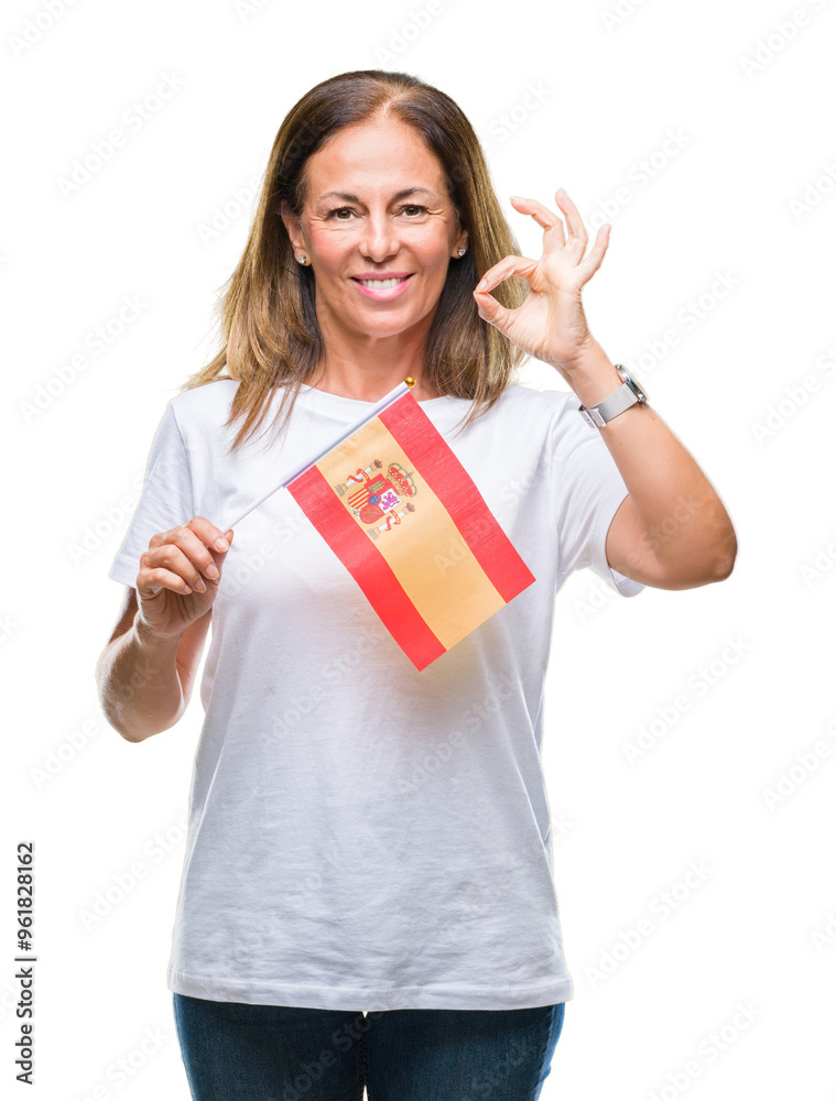 Middle age hispanic woman holding flag of Spain over isolated background doing ok sign with fingers, excellent symbol Middle age hispanic woman holding flag of Spain over isolated background doing ok sign with fingers, excellent symbol