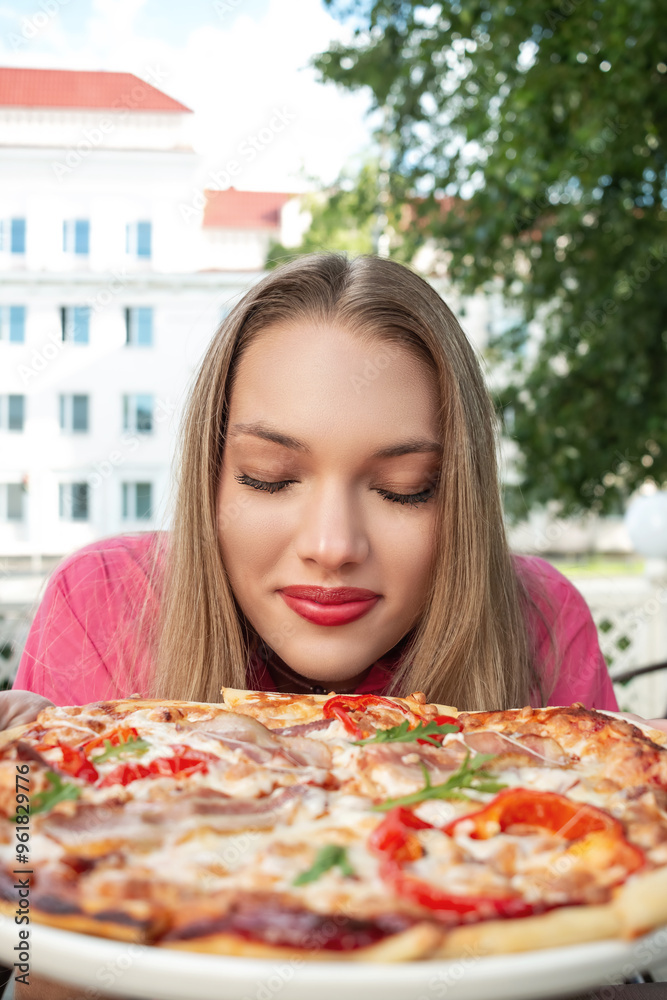 Girl in pink holding pizza in summer cafe. Girl in pink holding pizza in summer cafe.