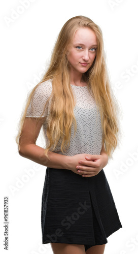 Blonde teenager woman wearing moles shirt with hand on stomach because nausea, painful disease feeling unwell. Ache concept.