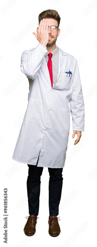Young handsome scientist man wearing glasses covering one eye with hand with confident smile on face and surprise emotion. Young handsome scientist man wearing glasses covering one eye with hand with confident smile on face and surprise emotion.