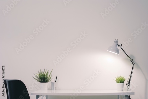 Simple workspace with plants and a lamp at a minimalist desk photo