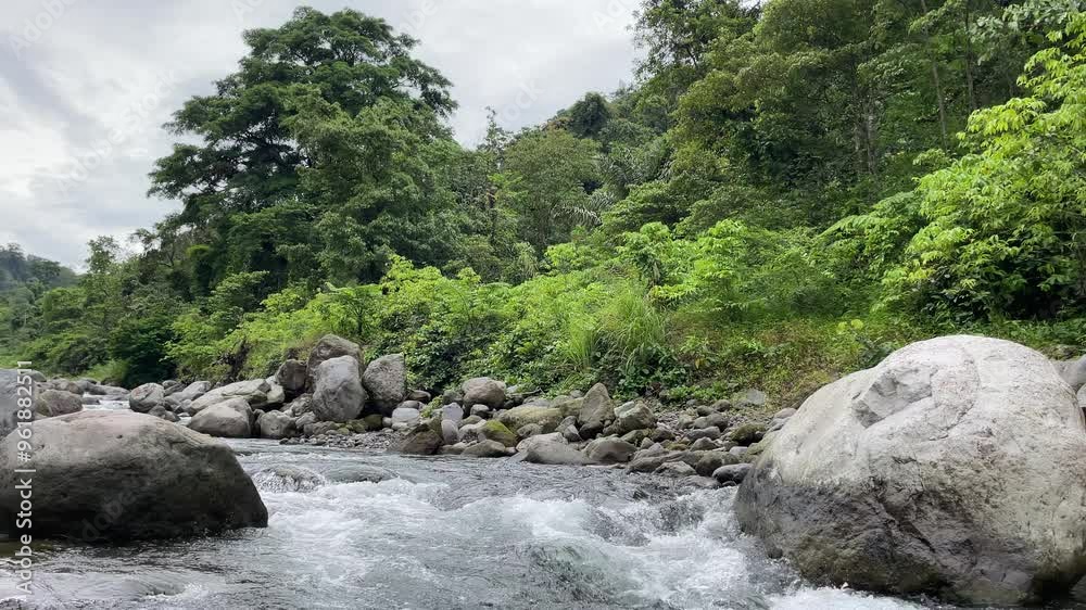 Rocks and water flow in river stream with green environment in North Sumatra, Indonesia Rocks and water flow in river stream with green environment in North Sumatra, Indonesia