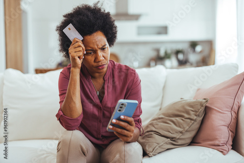 Worried Woman Checking Finances on Mobile Phone at Home