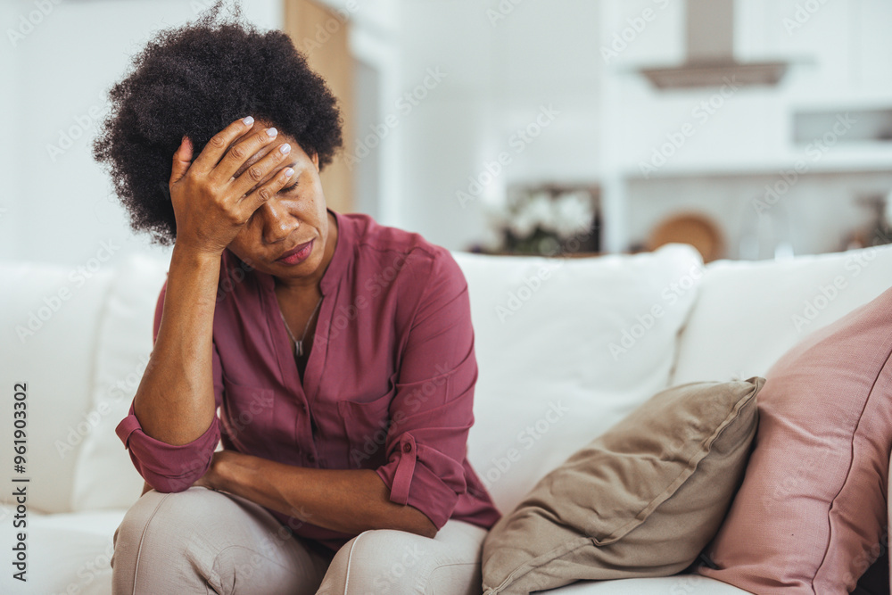 Stressed Woman Sitting On Sofa Holding Head In Hand Stressed Woman Sitting On Sofa Holding Head In Hand