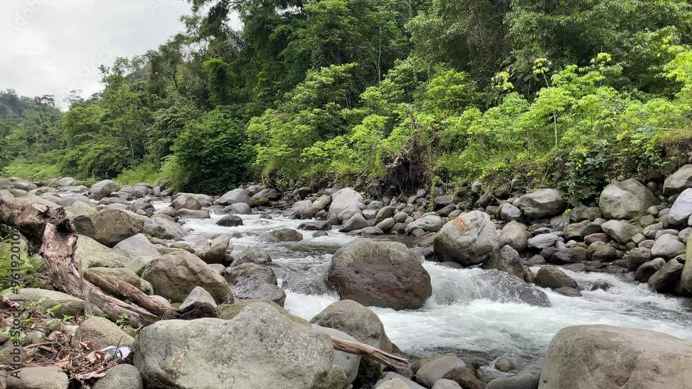 River stream with rocks and green scenery in North Sumatra, Indonesia River stream with rocks and green scenery in North Sumatra, Indonesia