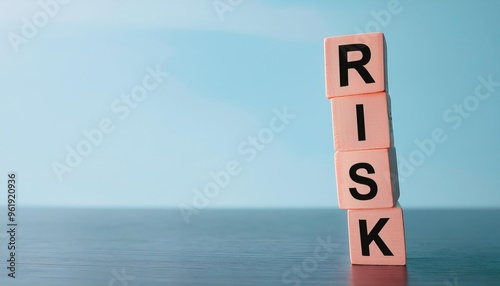 Conceptual image showcasing the word 'RISK' on building blocks against a serene background, symbolizing risk management and decisions.