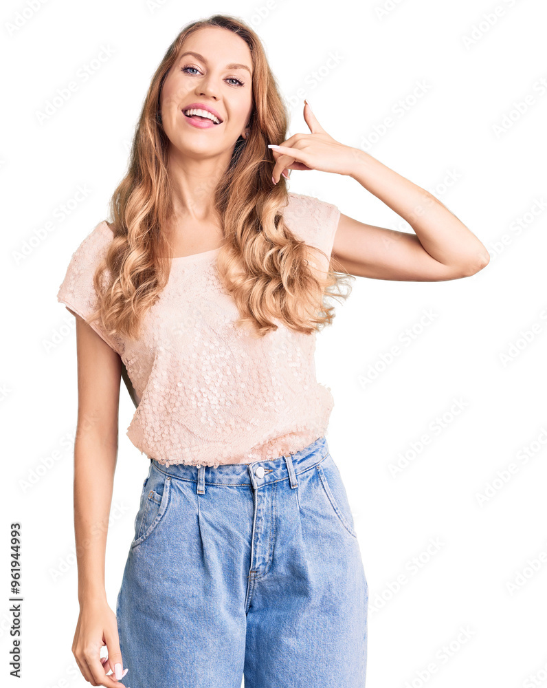 Young beautiful caucasian woman with blond hair wearing casual clothes smiling doing phone gesture with hand and fingers like talking on the telephone. communicating concepts. Young beautiful caucasian woman with blond hair wearing casual clothes smiling doing phone gesture with hand and fingers like talking on the telephone. communicating concepts.