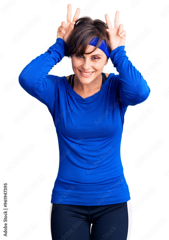 Beautiful young woman with short hair wearing training workout clothes posing funny and crazy with fingers on head as bunny ears, smiling cheerful Beautiful young woman with short hair wearing training workout clothes posing funny and crazy with fingers on head as bunny ears, smiling cheerful