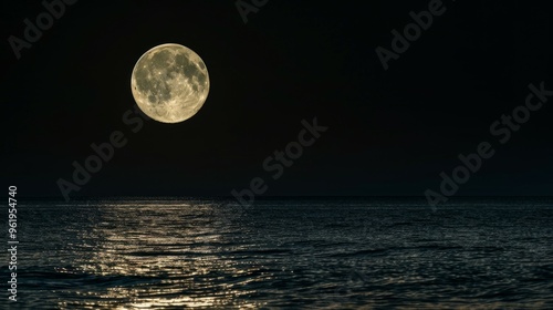 Night sky with big blue moon rises above the sea photo