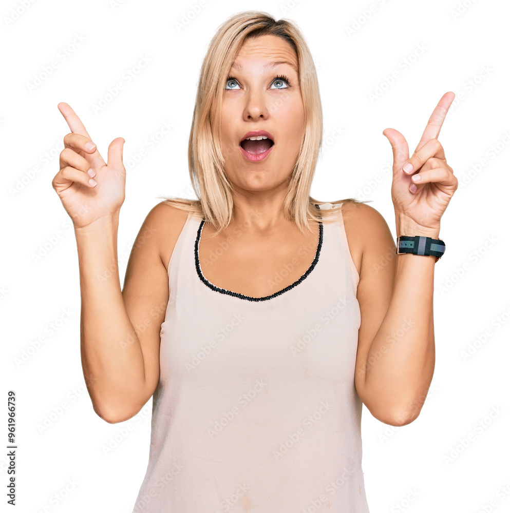 Middle age caucasian woman wearing casual clothes amazed and surprised looking up and pointing with fingers and raised arms. Middle age caucasian woman wearing casual clothes amazed and surprised looking up and pointing with fingers and raised arms.