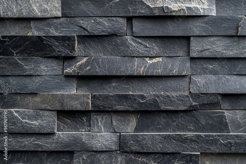 Dark gray slate wall cladding background, the texture of a natural stone panel for interior or exterior decoration.