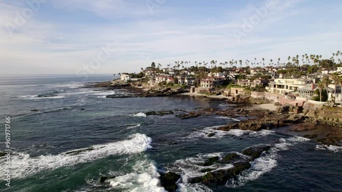 Aerial Drone views flying along the La Jolla coast near Birdrock neighborhood with views of the luxury home along the cliffs  overlooking the Pacific Ocean and rocky shoreline in San Diego California  photo