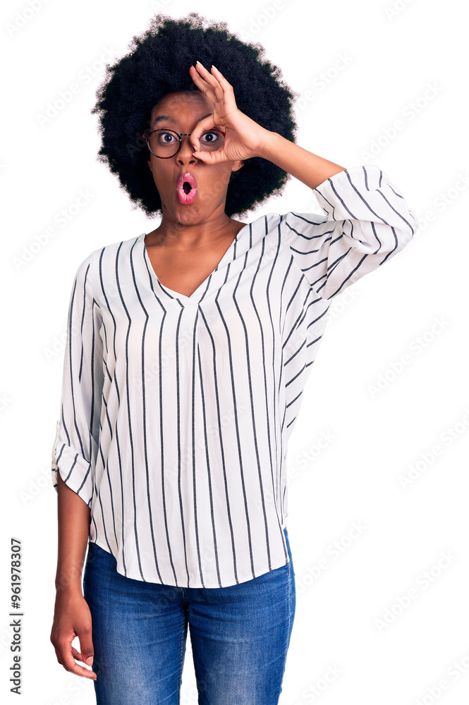 Young african american woman wearing casual clothes and glasses doing ok gesture shocked with surprised face, eye looking through fingers. unbelieving expression.
