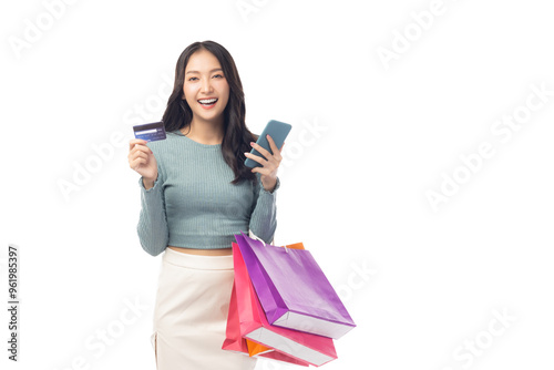 Cheerful young woman hold credit card and shopping bags, showcasing a positive shopping experience. Creates modern and fresh atmosphere, perfect for illustrating ecommerce or retail concepts.