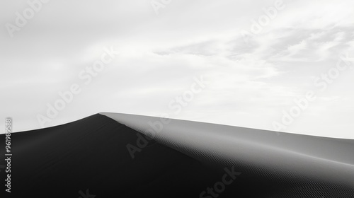 Black and white sand dune rising against a vast, empty sky, gentle curves and expansive horizon evoke isolation and serene simplicity in minimalist landscape