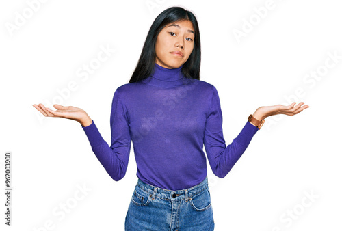 Beautiful young asian woman wearing casual clothes clueless and confused expression with arms and hands raised. doubt concept.