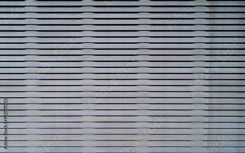 White slatted fence. Close-up of a white slatted fence, creating a repeating pattern of lines and texture.