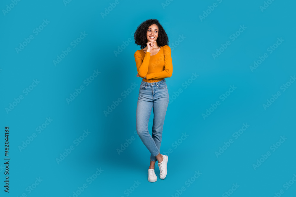 Full body photo of attractive young woman minded look empty space dressed stylish yellow clothes isolated on blue color background Full body photo of attractive young woman minded look empty space dressed stylish yellow clothes isolated on blue color background