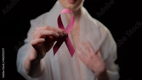 Woman who underwent breast cancer surgery shows pink ribbon photo