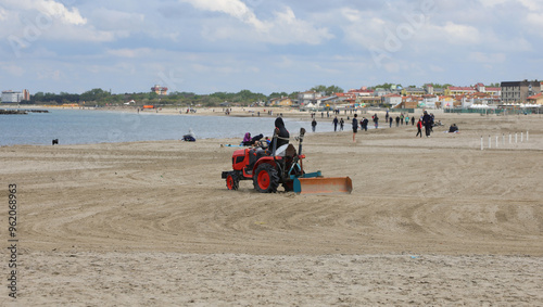 tractor for cleaning the beach and to remove all the debris the branches of the sand makes it more comfortable for the tourists photo