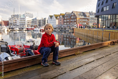 Cute preschool child, boy, on  a sunny day in Tromso, visiting the bigest northern city in Northern Norway photo