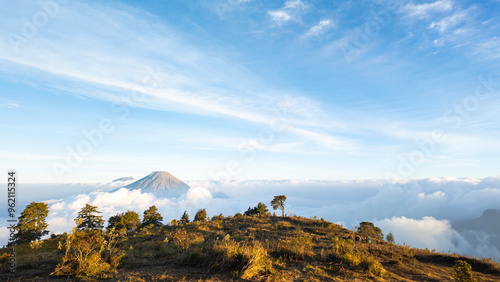 Mount Sindoro seen afar from Mount Prau panorama with blue sky and white clouds in Dieng, Wonosobo, Indonesia. Concept for International Day of Forest, World Environment Day. photo