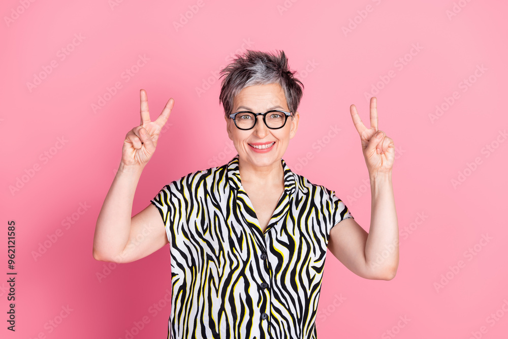 Photo of nice aged woman show v-sign wear zebra print shirt isolated on pink color background Photo of nice aged woman show v-sign wear zebra print shirt isolated on pink color background