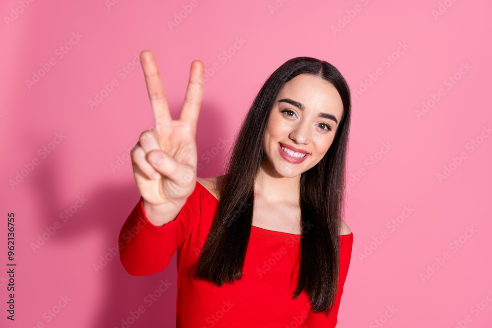 Portrait of pretty young woman show v-sign red shirt isolated on pink color background