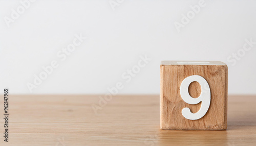 Wooden cube with number 9 on wooden table, white wall on background. Event planner, calendar