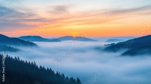 Sunrise breaking through morning fog over rolling hills, foggy weather, peaceful dawn