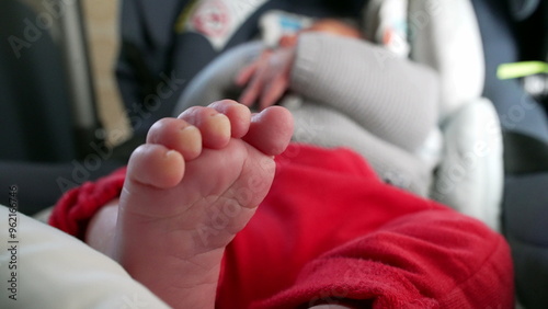 Close-up of baby’s tiny feet, soft and tender toes, relaxed infant in car seat, cozy and calm atmosphere, detailed view of newborn’s feet, intimate and loving moment, peaceful and comfortable rest