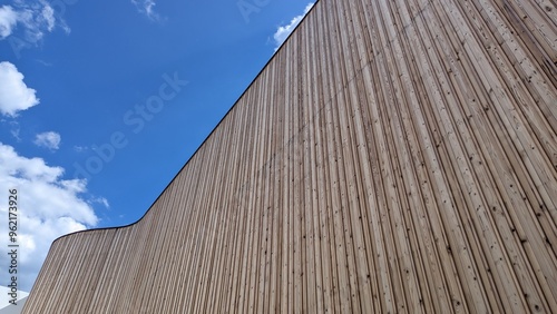 A large wooden building is set against a beautiful blue sky