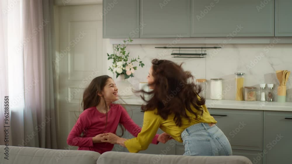 Joyful happy laughing Caucasian family woman female mother dancer holding hands little girl child kid daughter dancing music celebrating moving day relocation dance together holidays indoor apartment Joyful happy laughing Caucasian family woman female mother dancer holding hands little girl child kid daughter dancing music celebrating moving day relocation dance together holidays indoor apartment