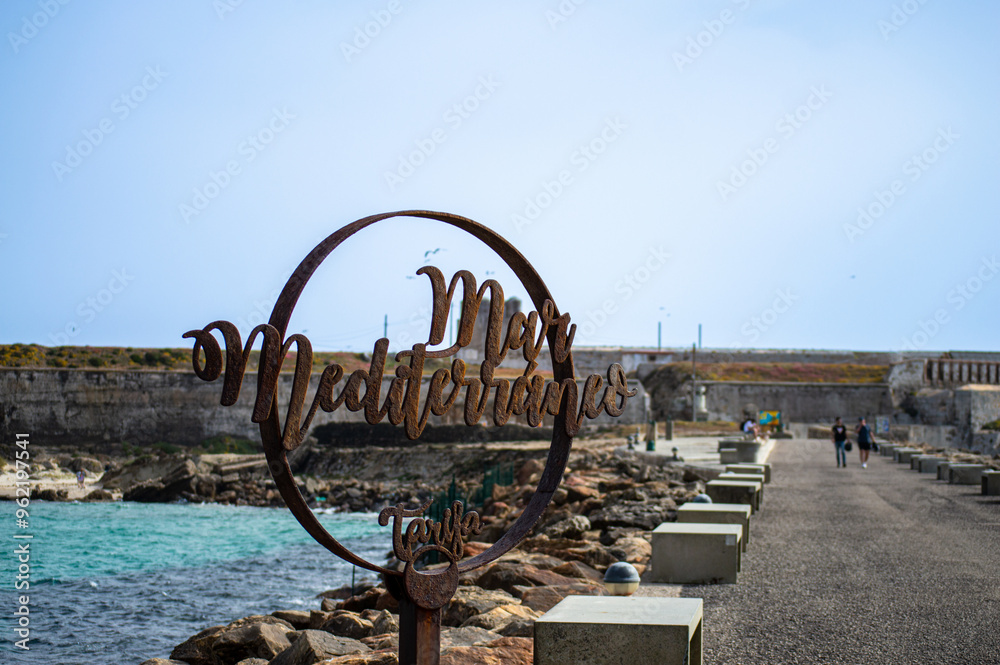 Fototapeta premium The famous symbol on the pathway that divides the Atlantic Ocean from the Mediterranean Sea in Tarifa, Spain